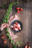 A rustic wooden table topped with colorful ice cream sandwiches and fresh fruit garnishes.