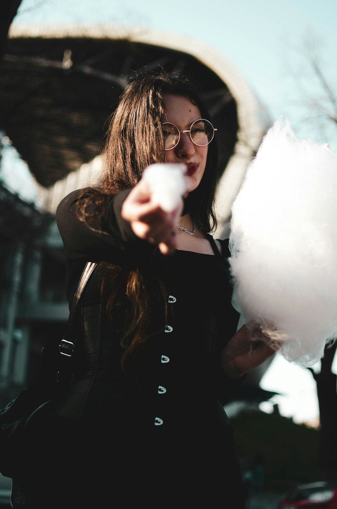 woman in black leather jacket holding white cotton candy