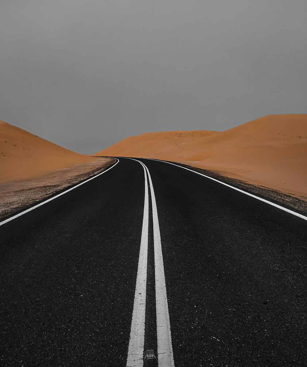 Route goudronnée noire au milieu du désert