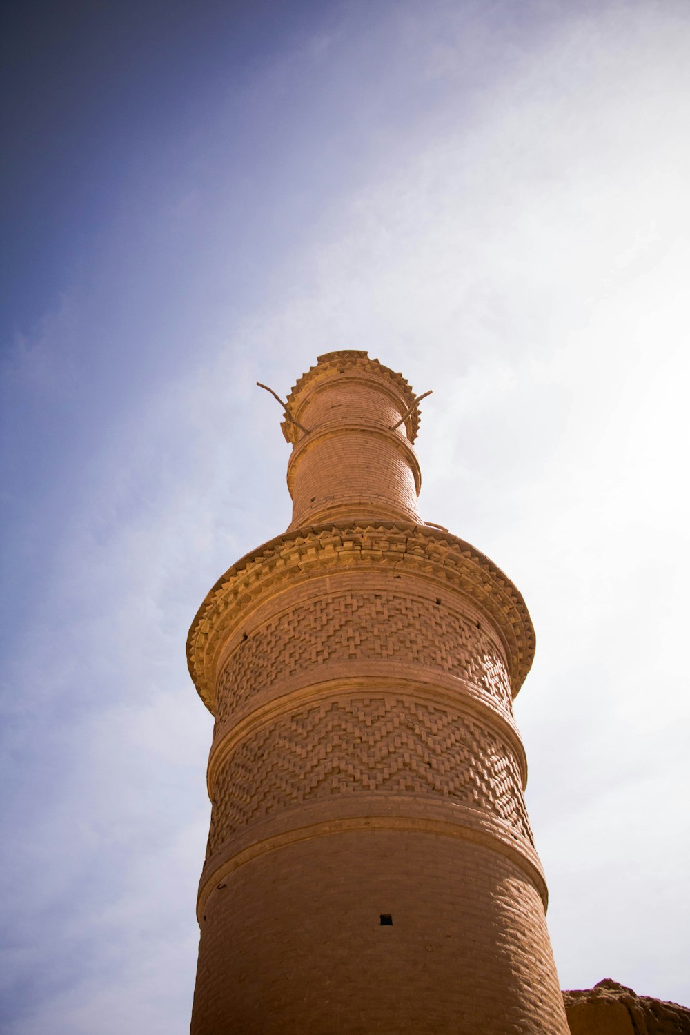 brown concrete tower under white clouds