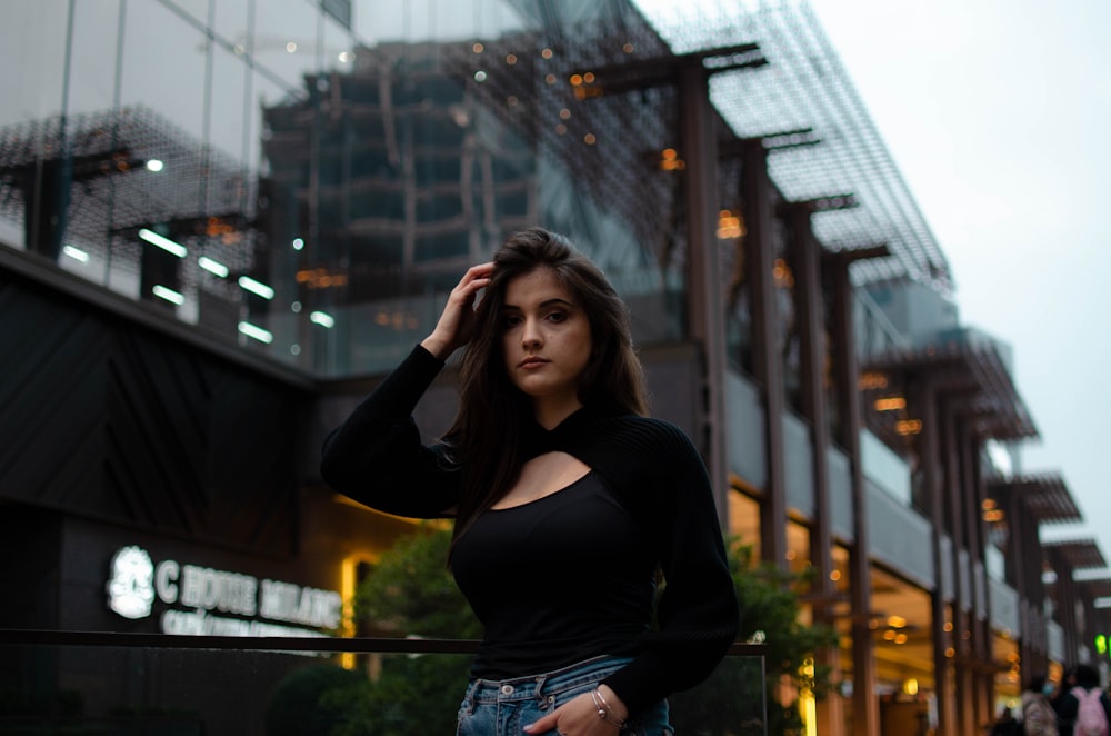 woman in black tank top standing on the building during daytime