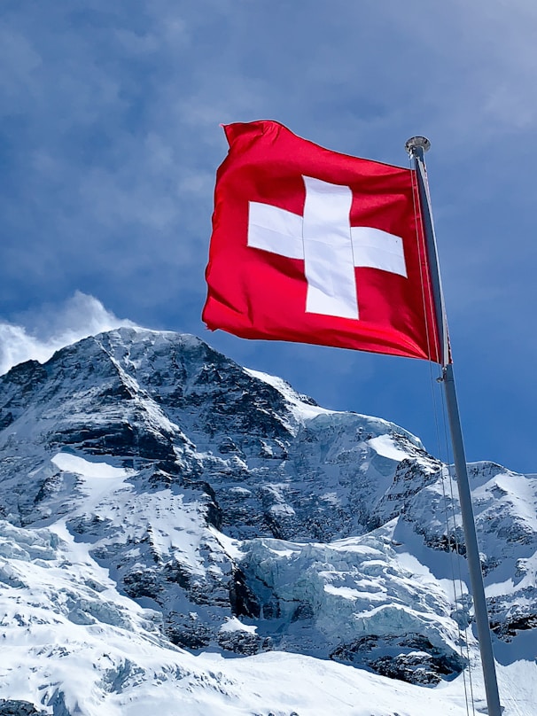 red flag on top of snow covered mountain