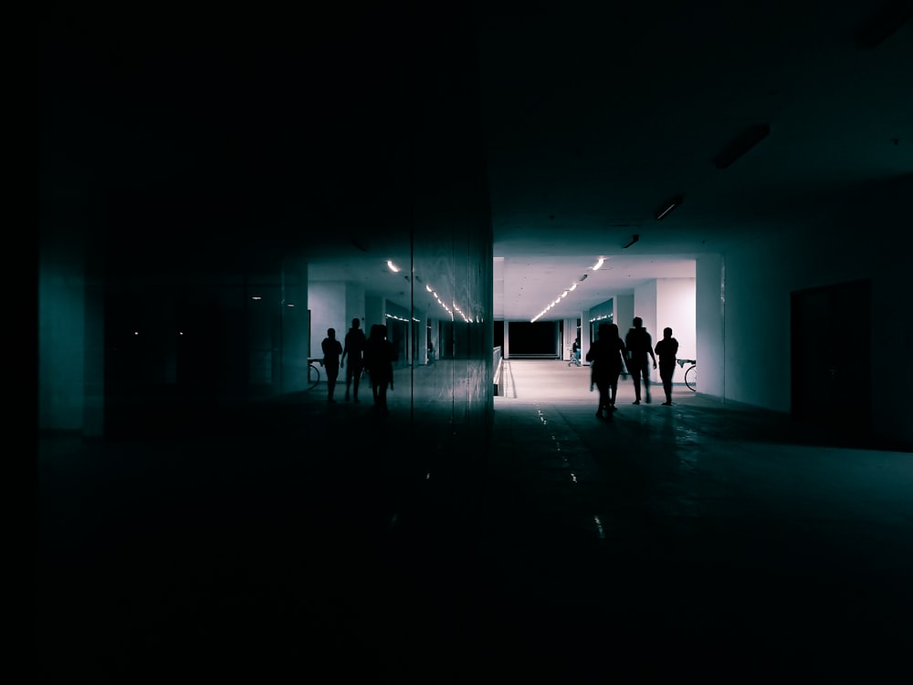 people walking on a blue lighted room