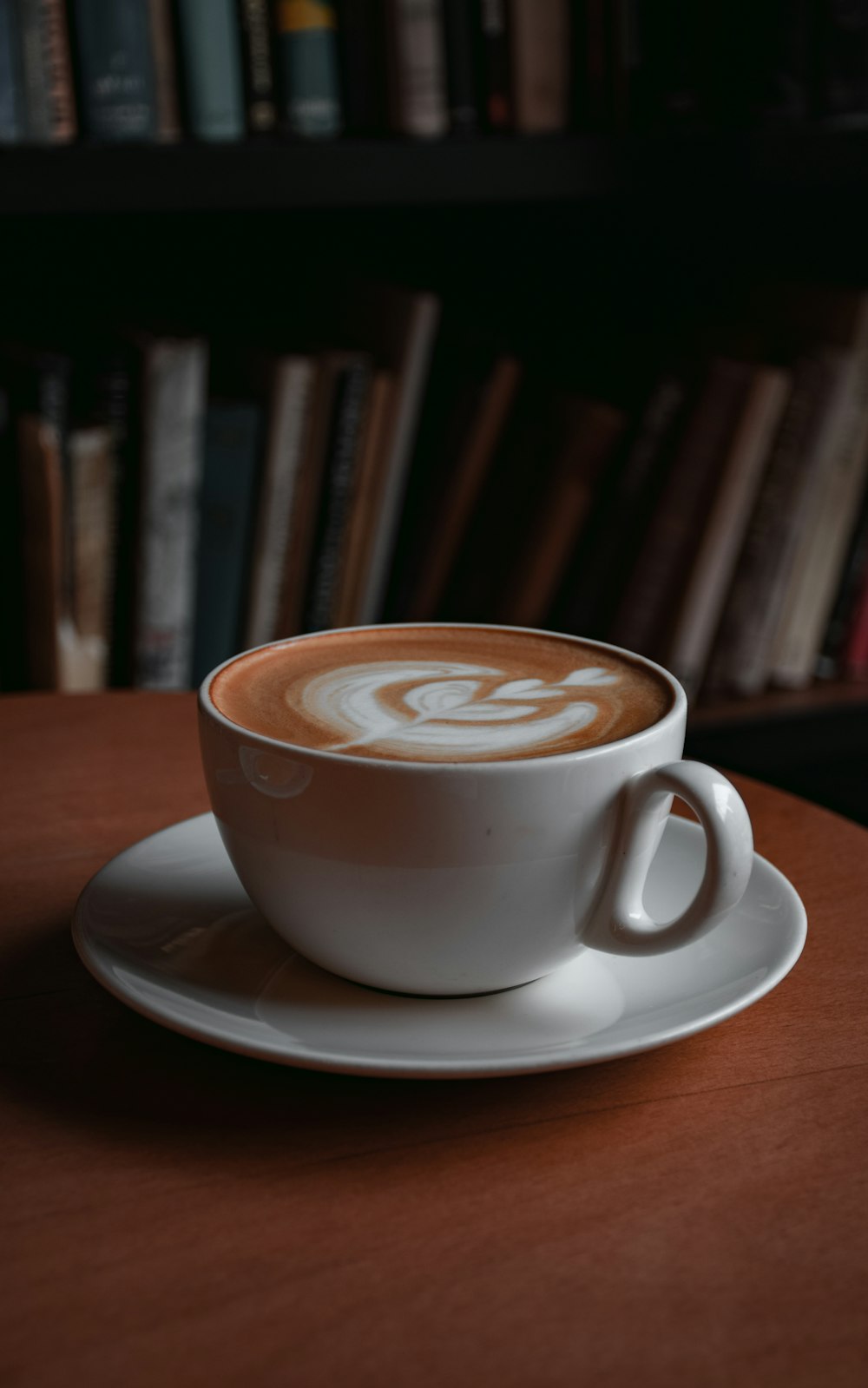 white ceramic cup with cappuccino on white ceramic saucer