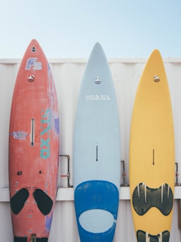 red and blue kayaks on white wooden fence