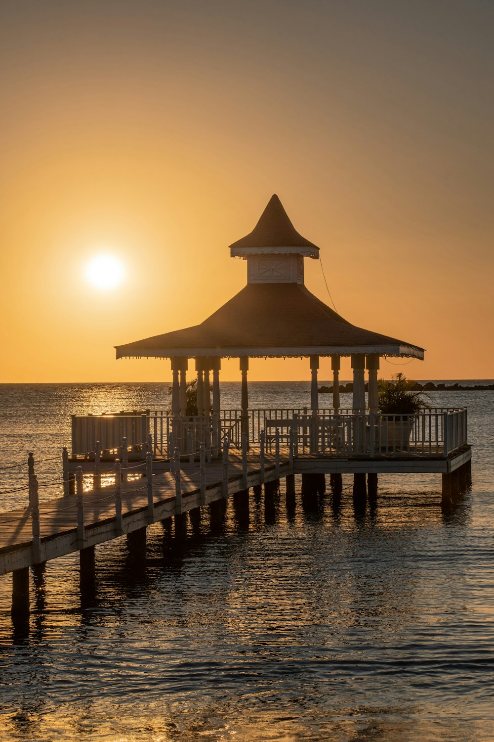 molo di legno marrone sul mare durante il tramonto