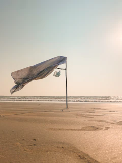 Soft ocean breeze ruffling a lightweight scarf draped over a beach chair