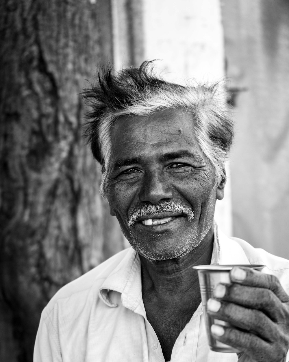 hombre en camisa blanca abotonada sosteniendo taza de cerámica blanca