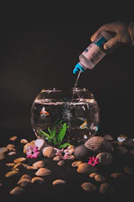 pouring medicine and water clearing substances into a fish tank