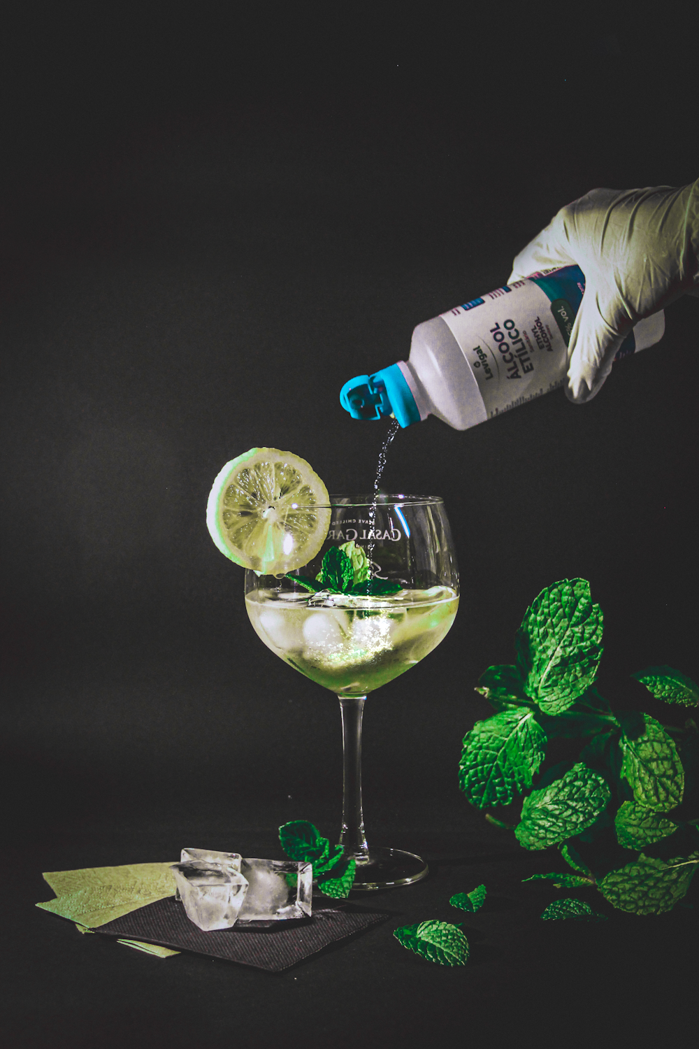 clear wine glass with sliced lemon and white labeled bottle