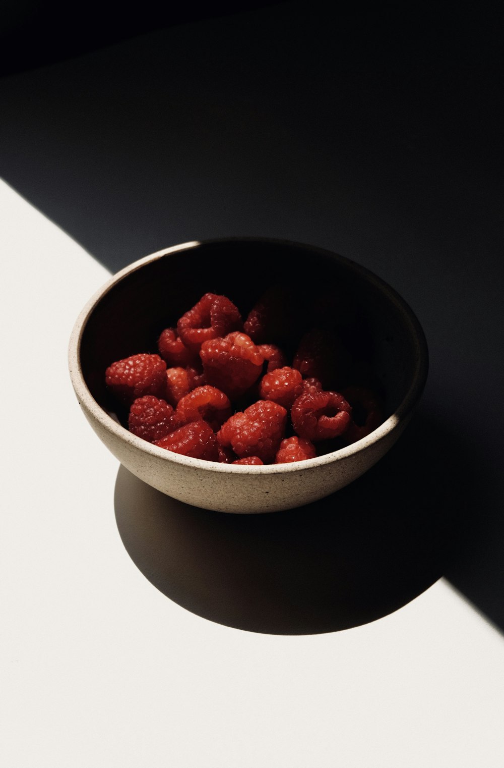 red strawberries in white ceramic bowl