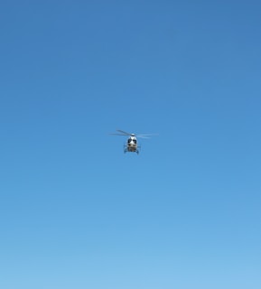 white and black drone flying under blue sky during daytime