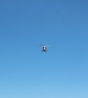 white and black drone flying under blue sky during daytime
