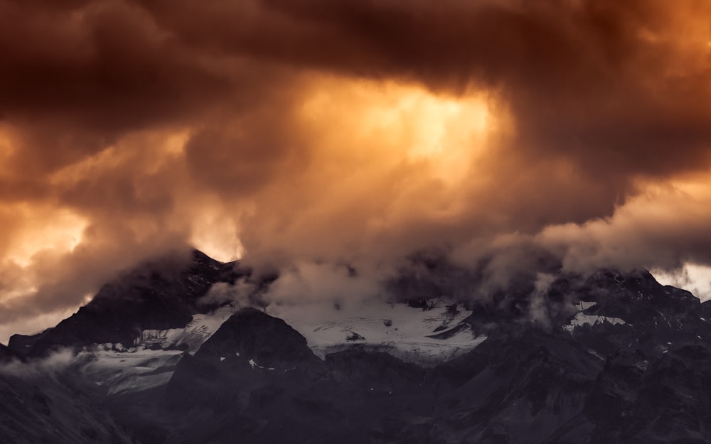 snow covered mountain under cloudy sky during daytime