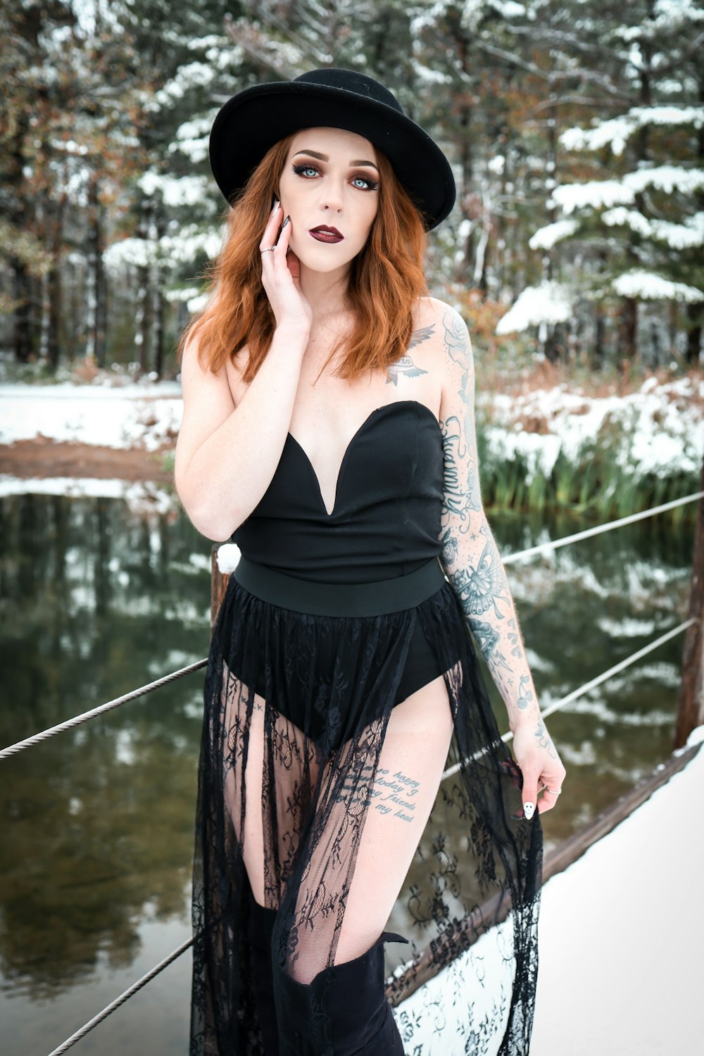 woman in black tank top and black and white skirt standing on bridge during daytime