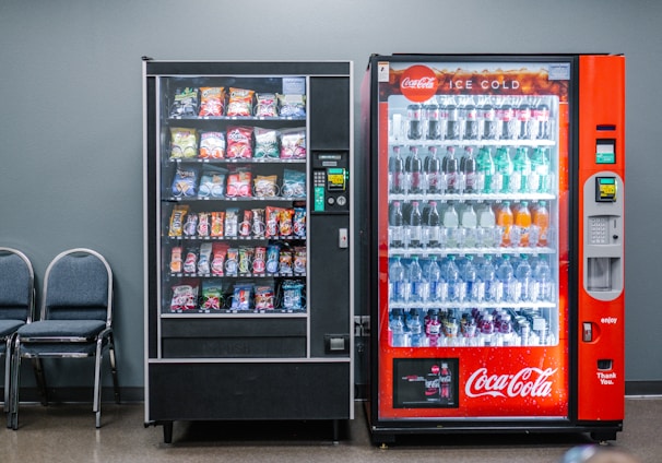 coca cola and coca cola bottles in black vending machine