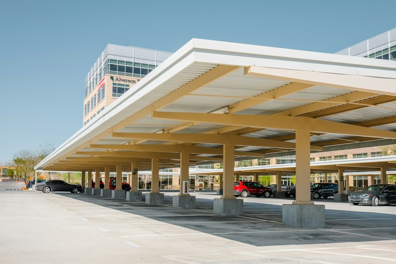 Solid-roof carport structure shading a row of parked cars