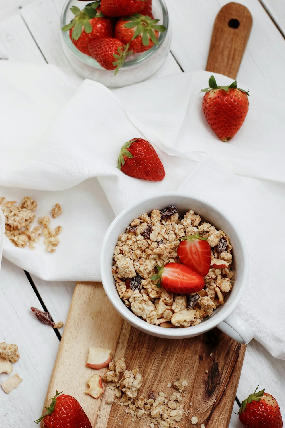 white ceramic bowl with red strawberries and brown nuts