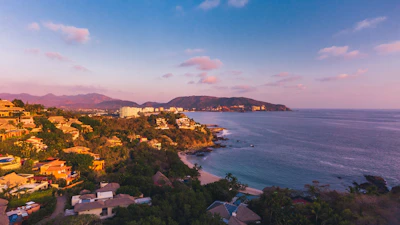 A beautiful coastal view of Trat with houses and land plots along the shoreline at sunset