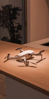 A cozy indoor scene with a drone on a shelf surrounded by plants and warm lighting.