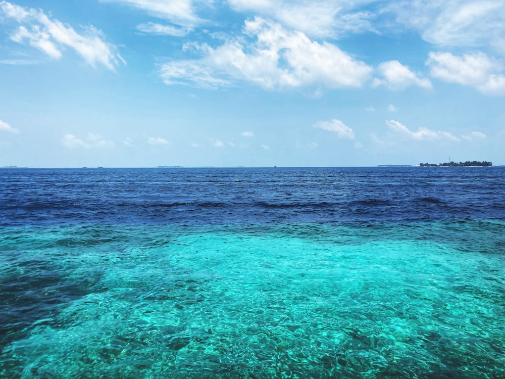 blue sea under blue sky and white clouds during daytime