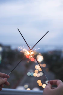 person holding sparkler during daytime