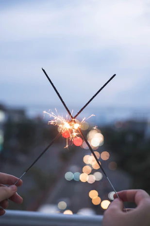 person holding sparkler during daytime