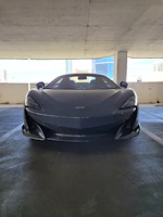 A sleek car being delivered with a city skyline in the background.