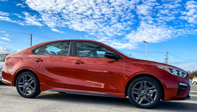 A sleek, reliable sedan parked in front of Highway 60 Motor Sales dealership on a sunny day.
