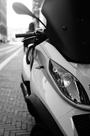 Close-up photo of a scooter similar to a delivery scooter, parked on a street.
