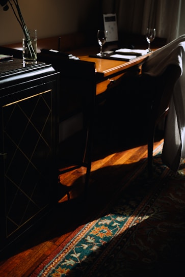 A sleek, modern detective's office with dark wood furniture and golden accents, softly lit.