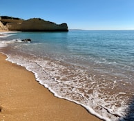 The golden sands and cliffside views of Varkala beach under a clear blue sky.