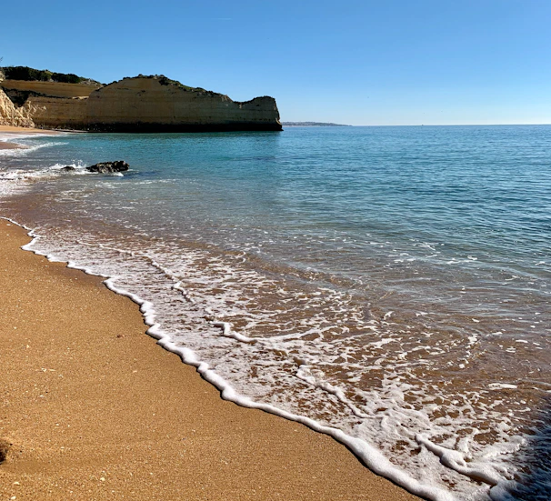 Golden sands and turquoise waters of Bali's pristine beaches under a clear blue sky.