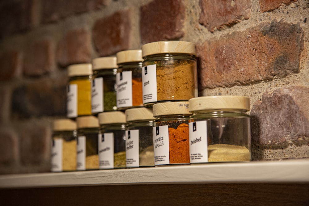 clear glass jars on brown wooden shelf