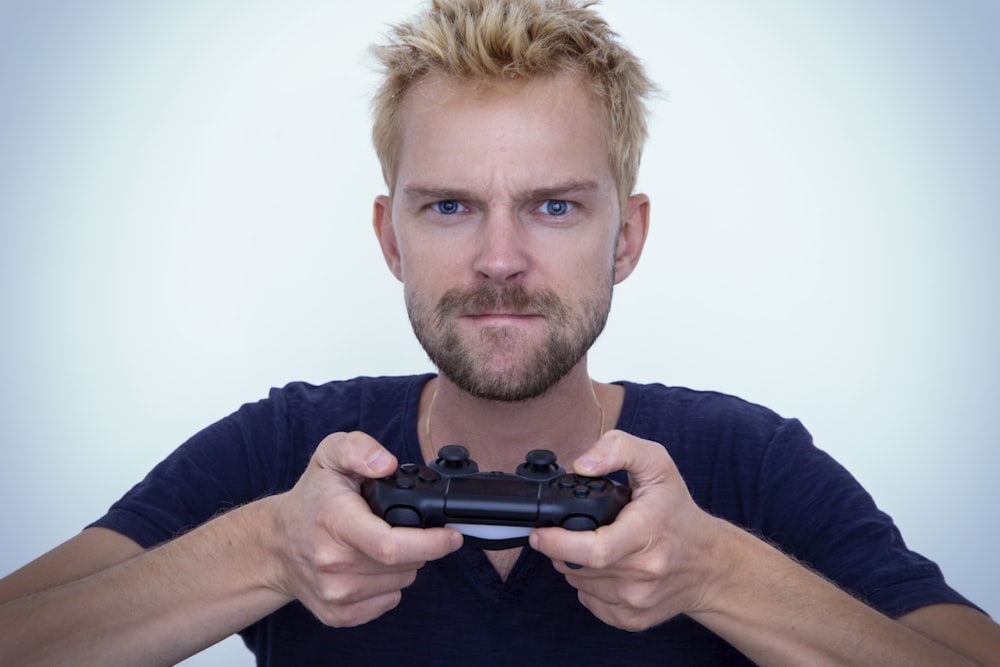 man in blue long sleeve shirt holding black semi automatic pistol