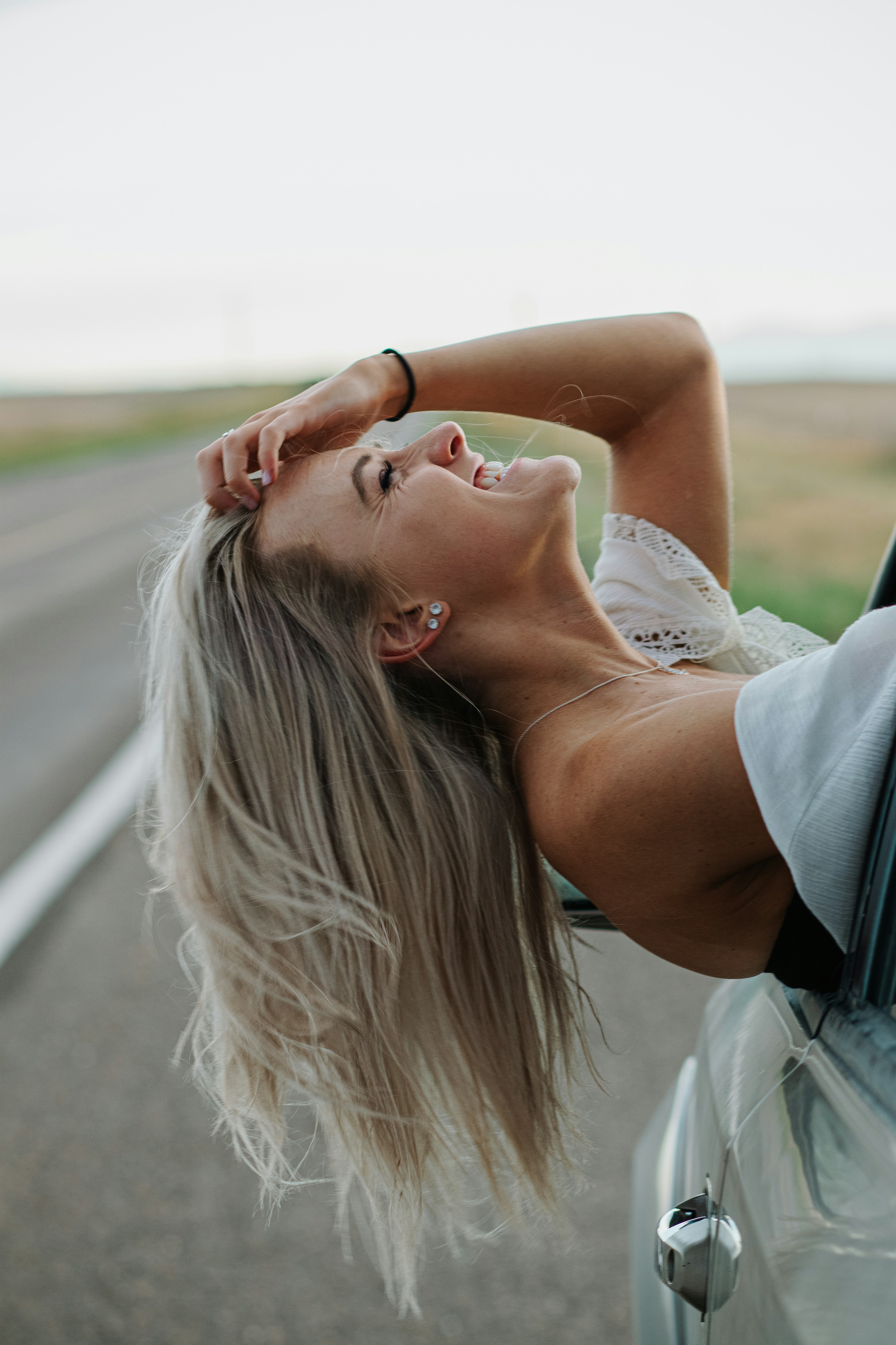 woman in white tank top lying on gray concrete floor during daytime