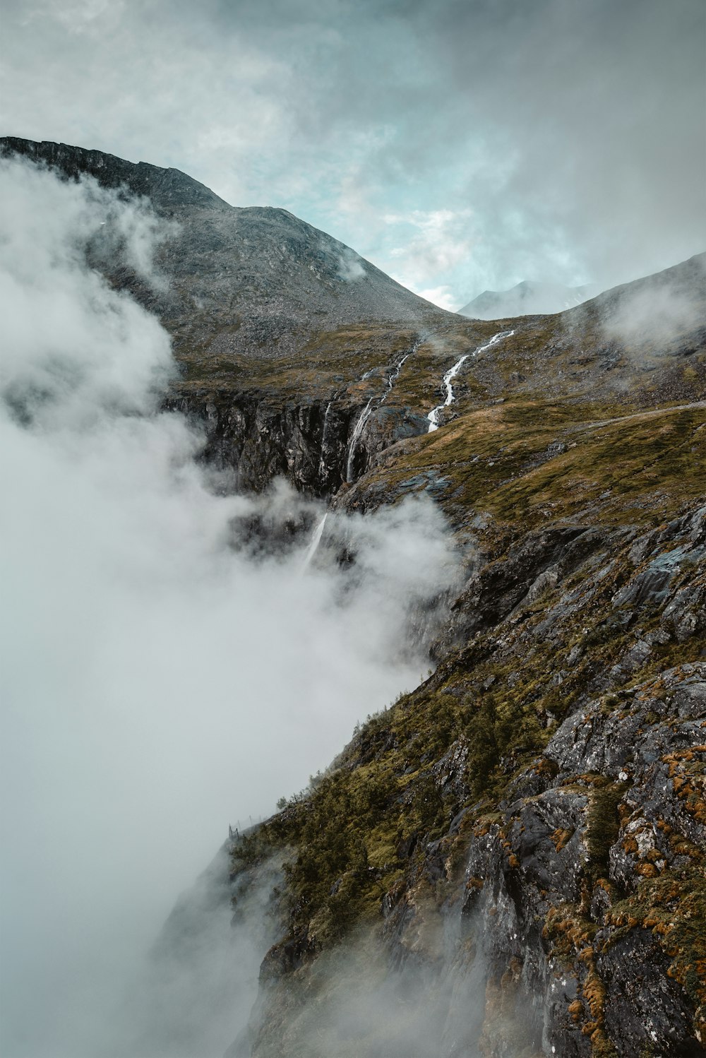 green and brown mountain under white clouds during daytime