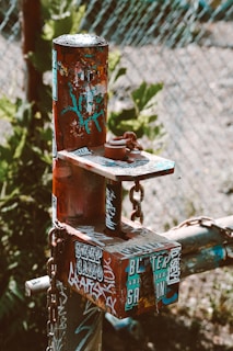 Close-up of a sturdy metal sign post being set into the ground by a professional installer wearing gloves.