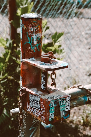 Close-up of a sturdy metal sign post being set into the ground by a professional installer wearing gloves.