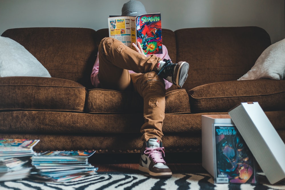 person in brown pants sitting on brown couch