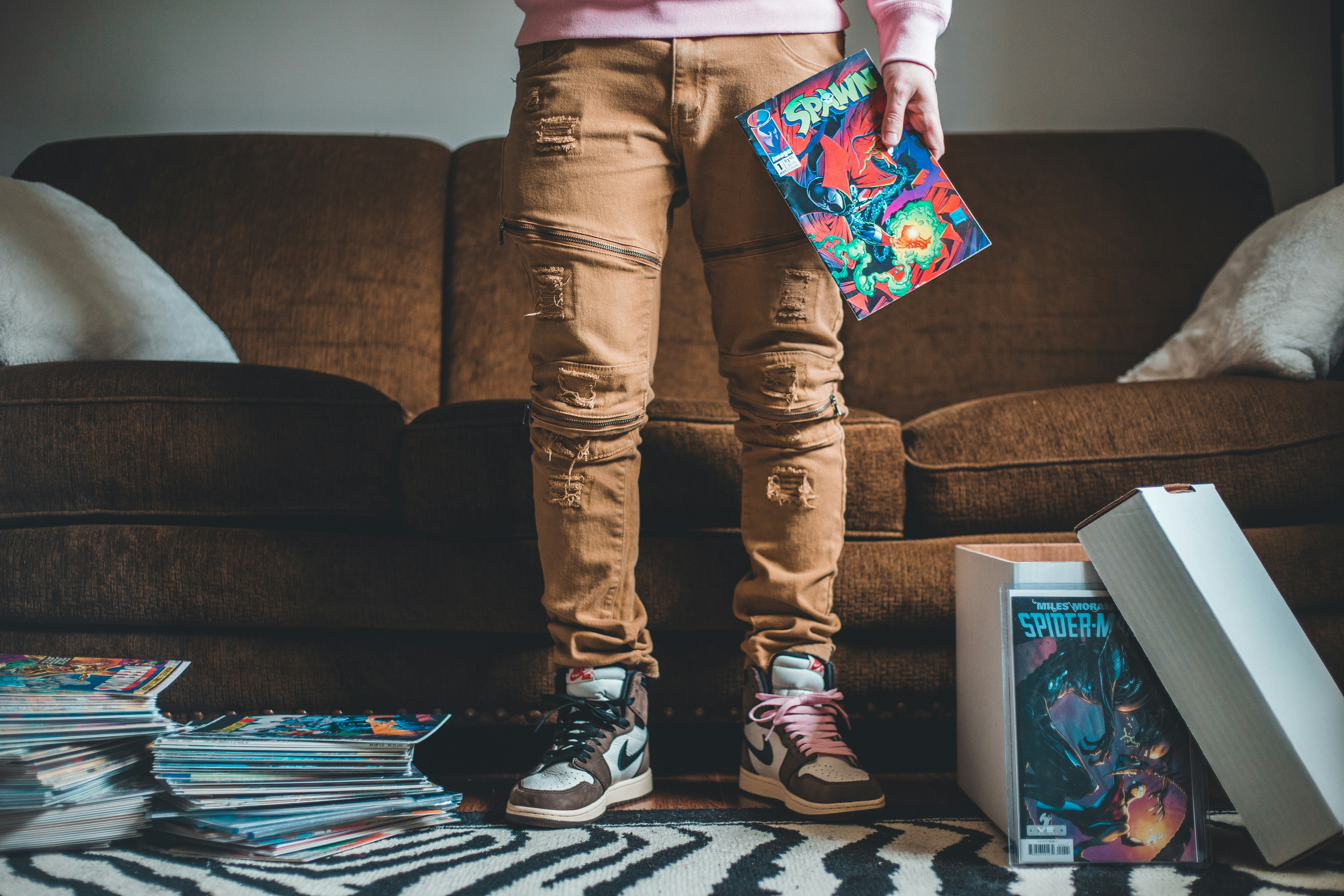 person in brown pants and black and white sneakers