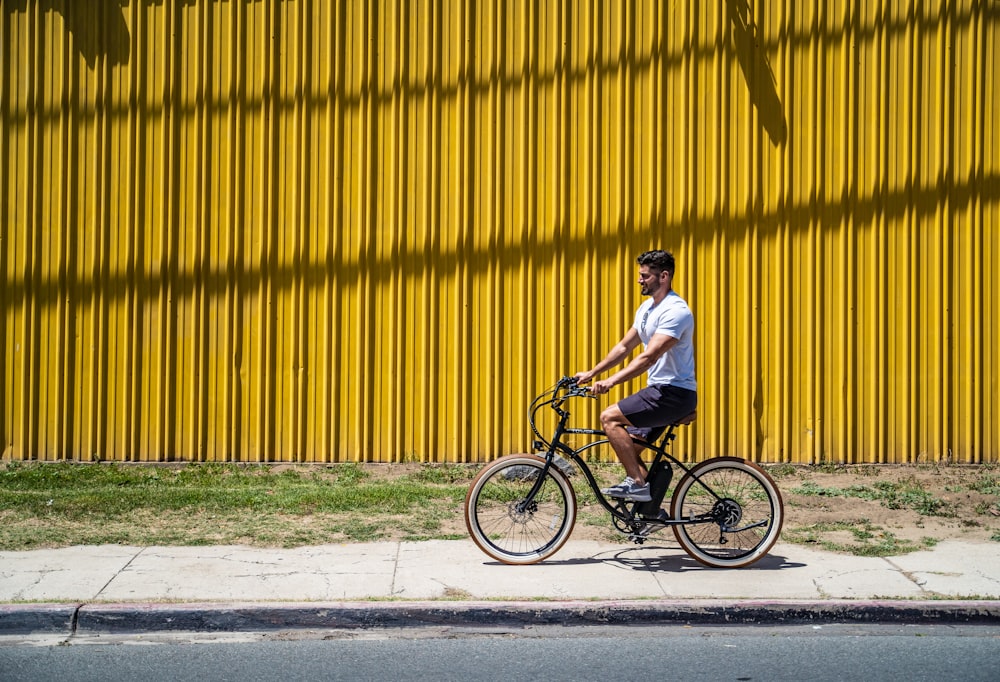 man in white shirt riding on black bicycle during daytime
