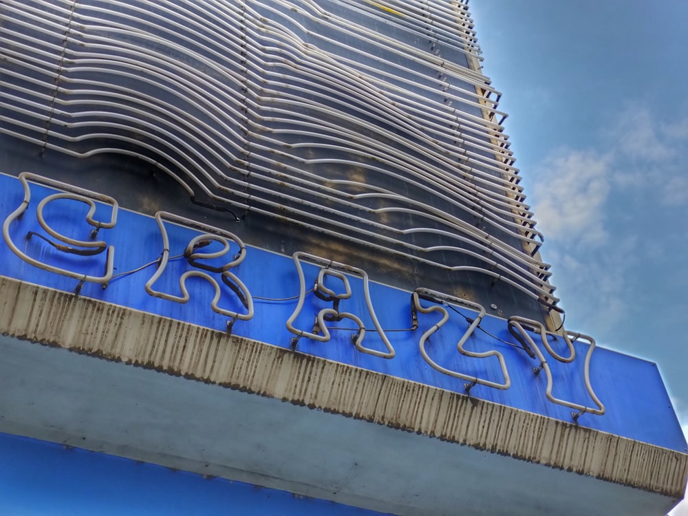 Edificio de hormigón azul y blanco bajo el cielo azul durante el día