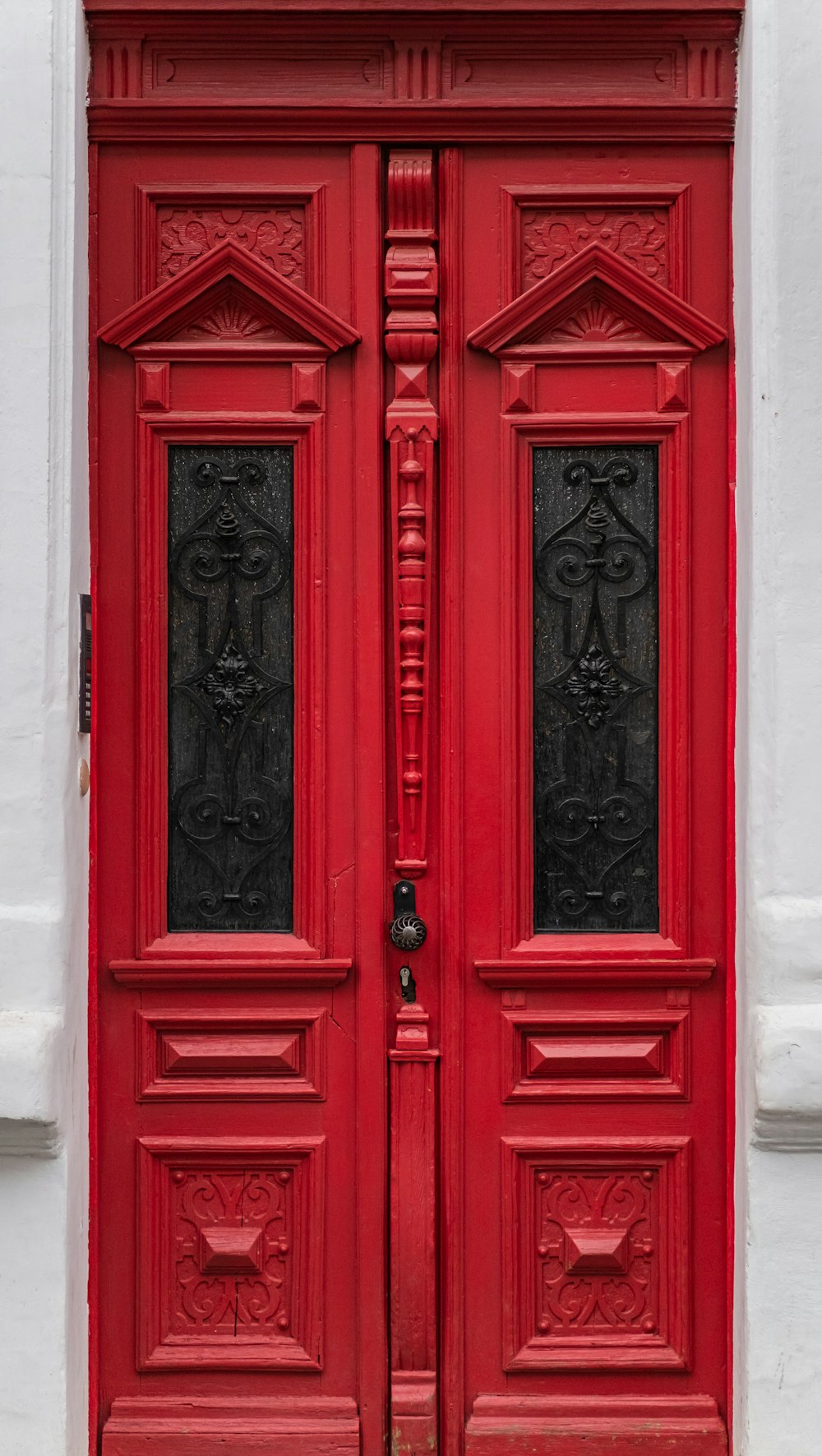 red wooden door with black steel door lever