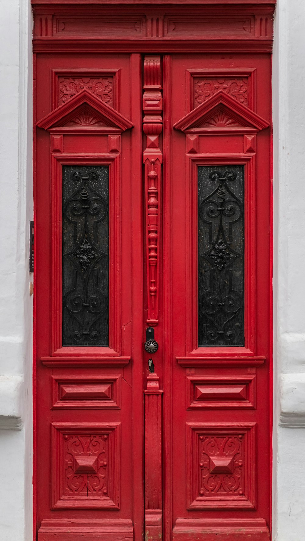 Porte en bois rouge avec levier de porte en acier noir