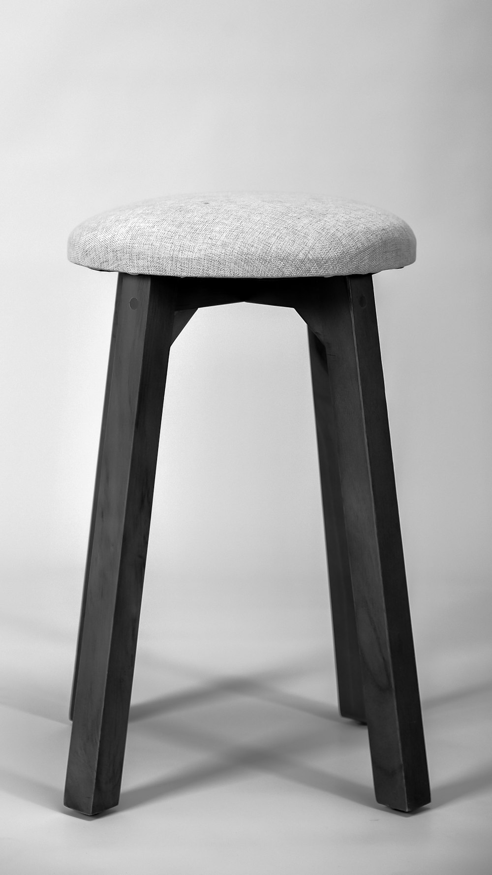 Asiento de madera gris sobre superficie blanca