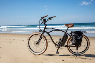 black commuter bike on beach during daytime