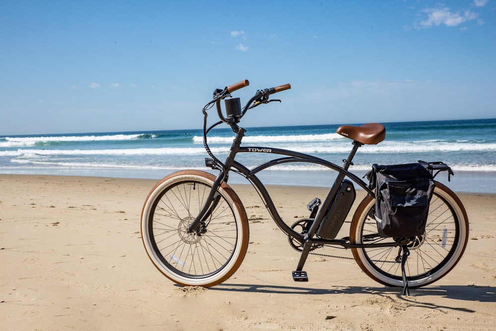 bicicleta de subúrbio preta na praia durante o dia