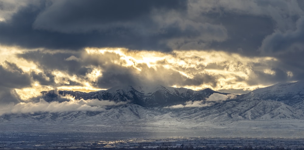 montanha coberta de neve sob céu nublado durante o dia