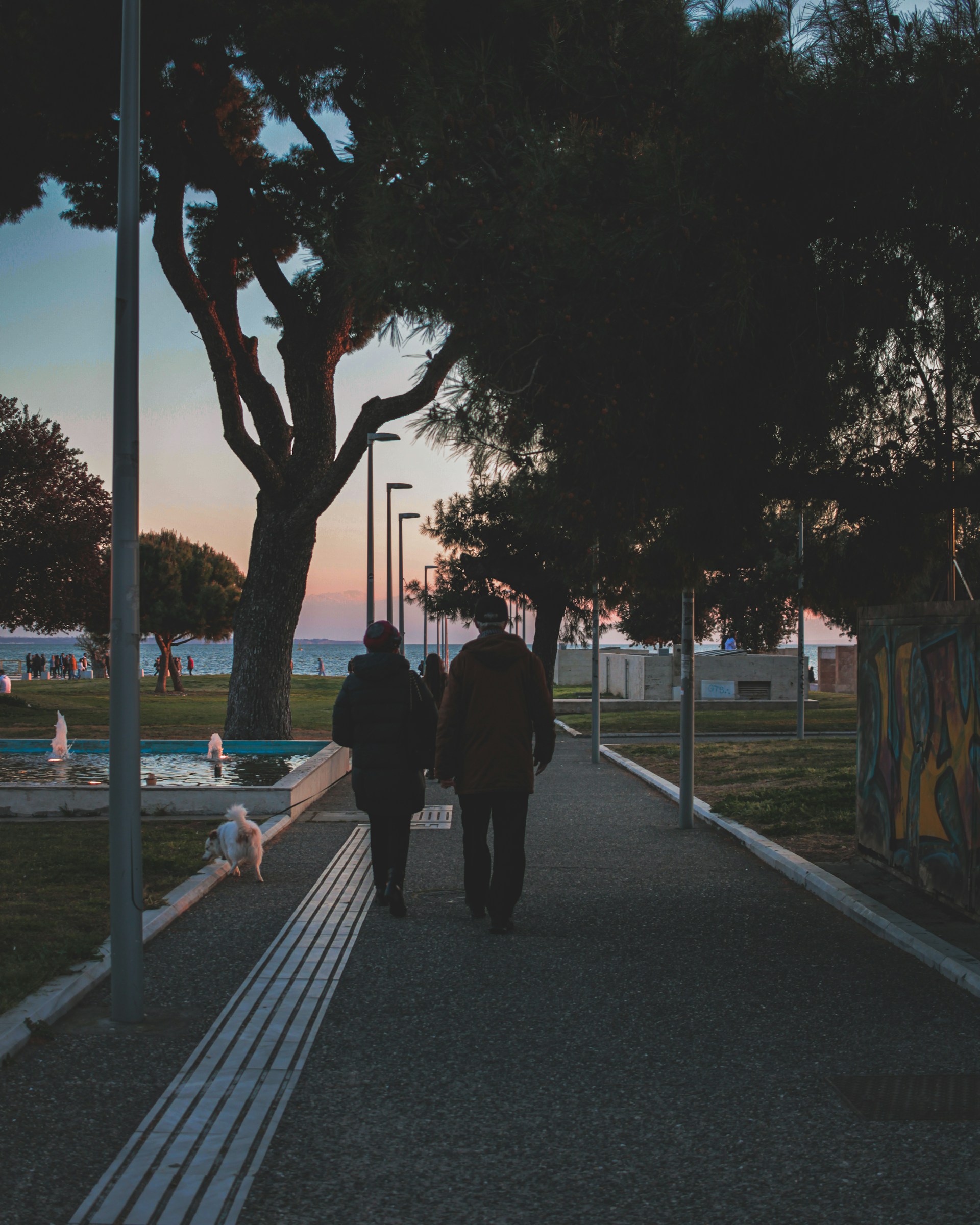 man in black jacket walking on sidewalk during daytime